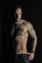 Bearded man with strong torso. Man with tattooed arm and chest. Tattoo model with sexy belly. Sportsman or athlete in