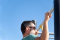 man with beard and sunglasses training his back by doing pull-ups on a bar in an outdoor gym Royalty Free Stock Photo