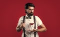 bearded man in suspenders drink red wine. brutal guy bartender in bow tie. elegant male barman. handsome hipster Royalty Free Stock Photo