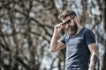 Bearded man takes off sunglasses on sunny day. Masculinity concept. Man with long beard looks stylish and confident. Man Royalty Free Stock Photo