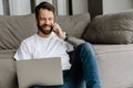 Bearded man talking on cellphone and working with laptop on floor Royalty Free Stock Photo