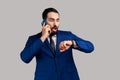 Bearded man talking phone and looking at wristwatch, being late for date or business meeting. Royalty Free Stock Photo