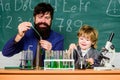 bearded man teacher with little boy. biotechnoloy research concept. father and son at school. Back to school. Explaining