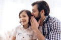 Bearded man tells secret to ear of teenager. Royalty Free Stock Photo