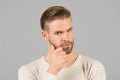 Bearded man touch beard with hand. Macho with stylish hair and healthy young skin. Guy with unshaven face and mustache. Beard groo