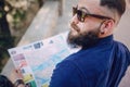 Bearded man travels with map