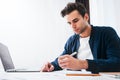 Bearded man using laptop and preparing project plan sitting at table his modern home Royalty Free Stock Photo