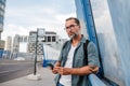 Bearded man using phone while waiting for bus. Royalty Free Stock Photo