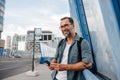 Bearded man using phone while waiting for bus. Royalty Free Stock Photo