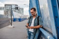 Bearded man using phone while waiting for bus. Royalty Free Stock Photo