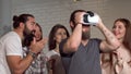 Bearded man using virtual reality glasses with his friends