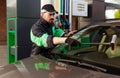 Bearded man washing windscreen of modern car