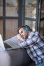 Bearded man wearing checked shirt having a nap after working