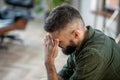 Bearded man wearing checked shirt having strong headache