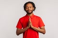 Bearded man wearing red T-shirt, concentrating his mind, keeping hands namaste gesture, meditating, yoga exercise breath technique