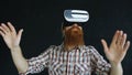Bearded man wearing virtual reality headset and having 360 VR experience on black background Royalty Free Stock Photo