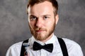 Bearded man in white shirt and bow tie showing shaver Royalty Free Stock Photo