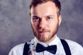 Bearded man in white shirt and bow tie showing shaver Royalty Free Stock Photo