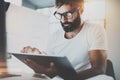 Bearded man in white tshirt working with portable electronic pro tablet computer at modern lightful office.Horizontal Royalty Free Stock Photo