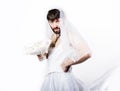 Bearded man in a woman`s wedding dress on her naked body, holding a flower. on his head a wreath of flowers. funny Royalty Free Stock Photo