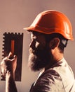 Bearded man worker, beard, building helmet, hard hat. Mason plastering concrete to build. Plastering tools. Tool, trowel Royalty Free Stock Photo