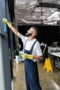 bearded man in workwear cleaning window Royalty Free Stock Photo