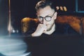 Bearded manager working modern loft office. Man sitting in vintage chair at night,thinkig new startup project.Using