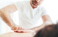 Bearded Masseur man doing massage manipulations on the Scapula area zone during young female body massaging Royalty Free Stock Photo