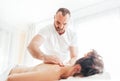 Bearded Masseur man doing massage manipulations on the Scapula area zone during young female body massaging