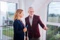 Bearded mature rich man asking questions while having consultation of estate agent