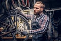 Mechanic doing bicycle wheel service manual in a workshop. Royalty Free Stock Photo