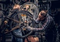 Mechanic doing bicycle wheel service manual in a workshop. Royalty Free Stock Photo