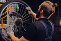Mechanic repairing bicycle wheel tire in a workshop. Royalty Free Stock Photo