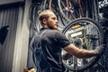 Mechanic repairing bicycle wheel tire in a workshop. Royalty Free Stock Photo