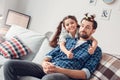 Father and little daughter at home sitting girl hugging father with funny hairstyle cheerful thumbs up