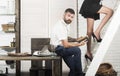 Bearded man read book with female legs on ladder Royalty Free Stock Photo