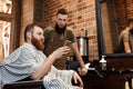 Barber and bearded man in barber shop