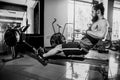 Muscular fit man using rowing machine at gym Royalty Free Stock Photo