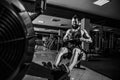 Muscular fit man using rowing machine at gym Royalty Free Stock Photo