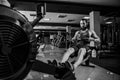 Muscular fit man using rowing machine at gym Royalty Free Stock Photo