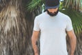 Bearded muscular hipster man model wearing gray blank t-shirt and a black baseball cap with space for your logo or