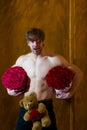 Bearded muscular man with body holds red rose box