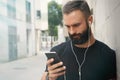 Bearded Muscular Man Wearing Black Tshirt Blank Snapback Cap Summer Time.Young Men Using Smartphone Headphones Looking