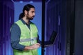 Bearded network technician working with servers in neon light Royalty Free Stock Photo