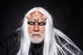 Bearded old man dressed like Halloween monster. Satan on Hell. Magic and fairy tale concept. Horned Devil in his home - Royalty Free Stock Photo