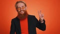 Bearded optimistic young man showing victory sign, hoping for success and win, doing peace gesture Royalty Free Stock Photo