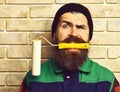 Bearded painter man holding roller paint with satisfied face Royalty Free Stock Photo