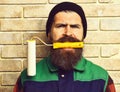 Bearded painter man holding roller paint with serious face Royalty Free Stock Photo