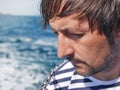 Bearded pensive male looking at the sea from yacht