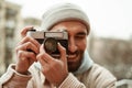 bearded photographer in beanie hat smiling